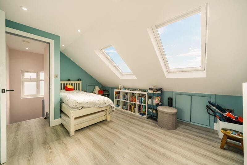Loft conversion children's bedroom with teal walls and skylights