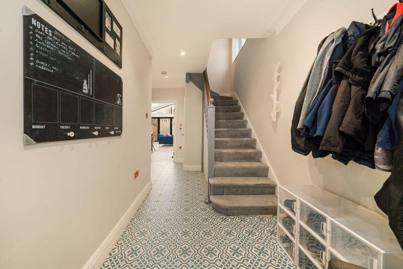 Hallway with patterned floor tiles and staircase