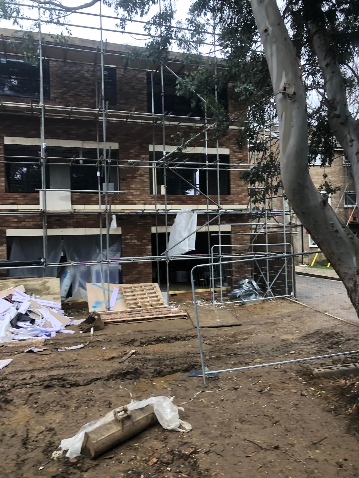 Golden Manor — construction site showing scaffolded rear elevation and groundworks in progress
