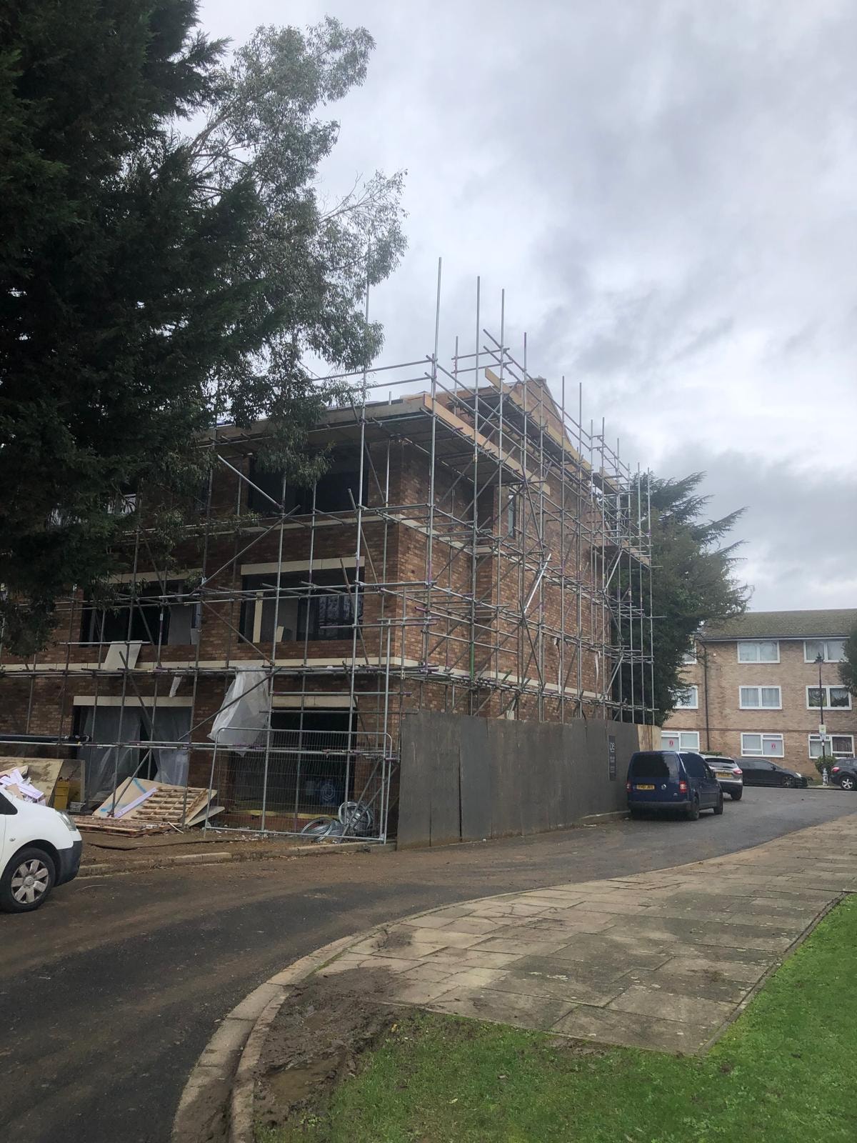 Golden Manor — scaffolded front elevation under construction with brickwork and roof structure forming