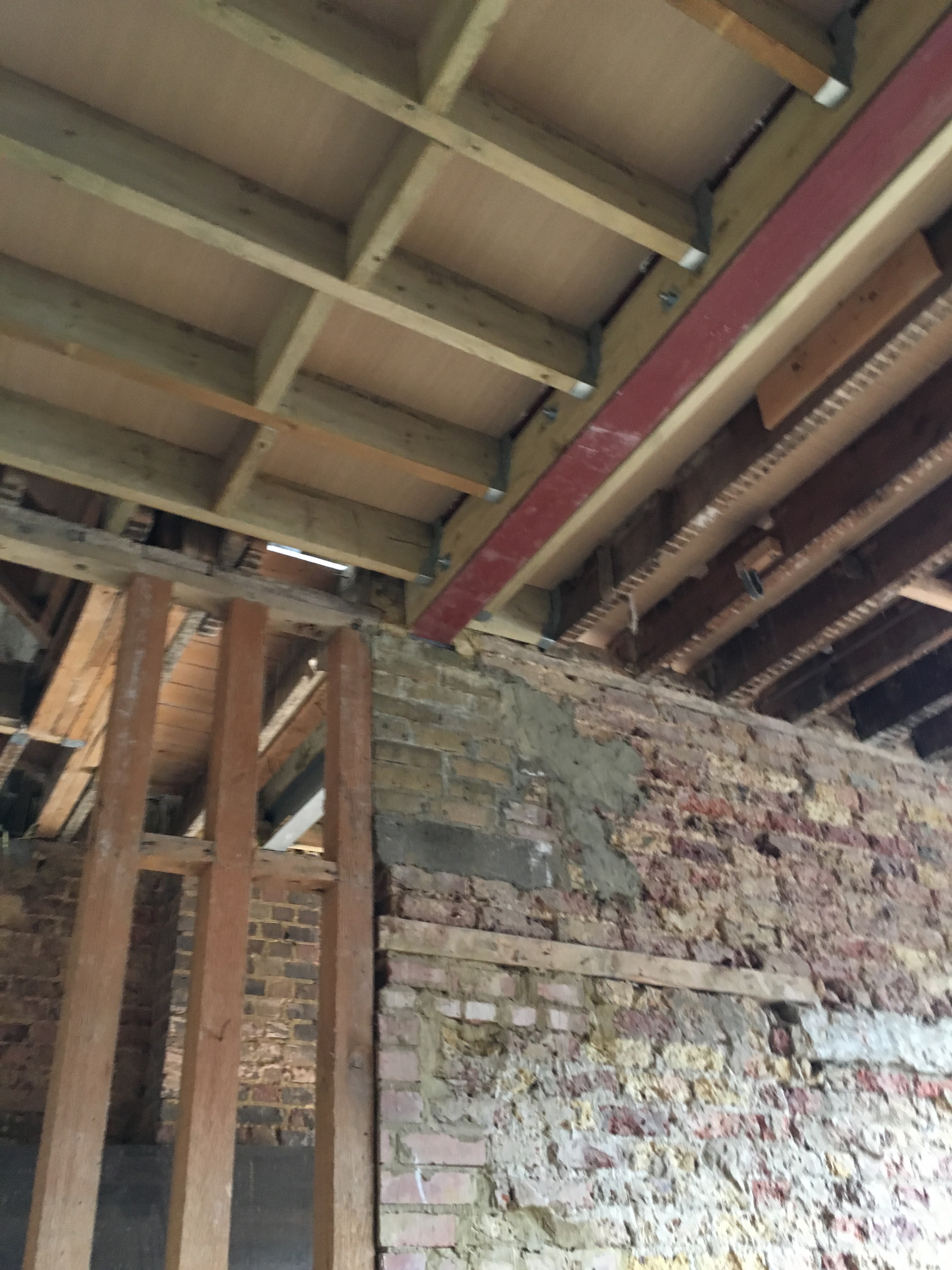 Gordon Road Ealing — interior timber floor joists and exposed brick wall during structural conversion
