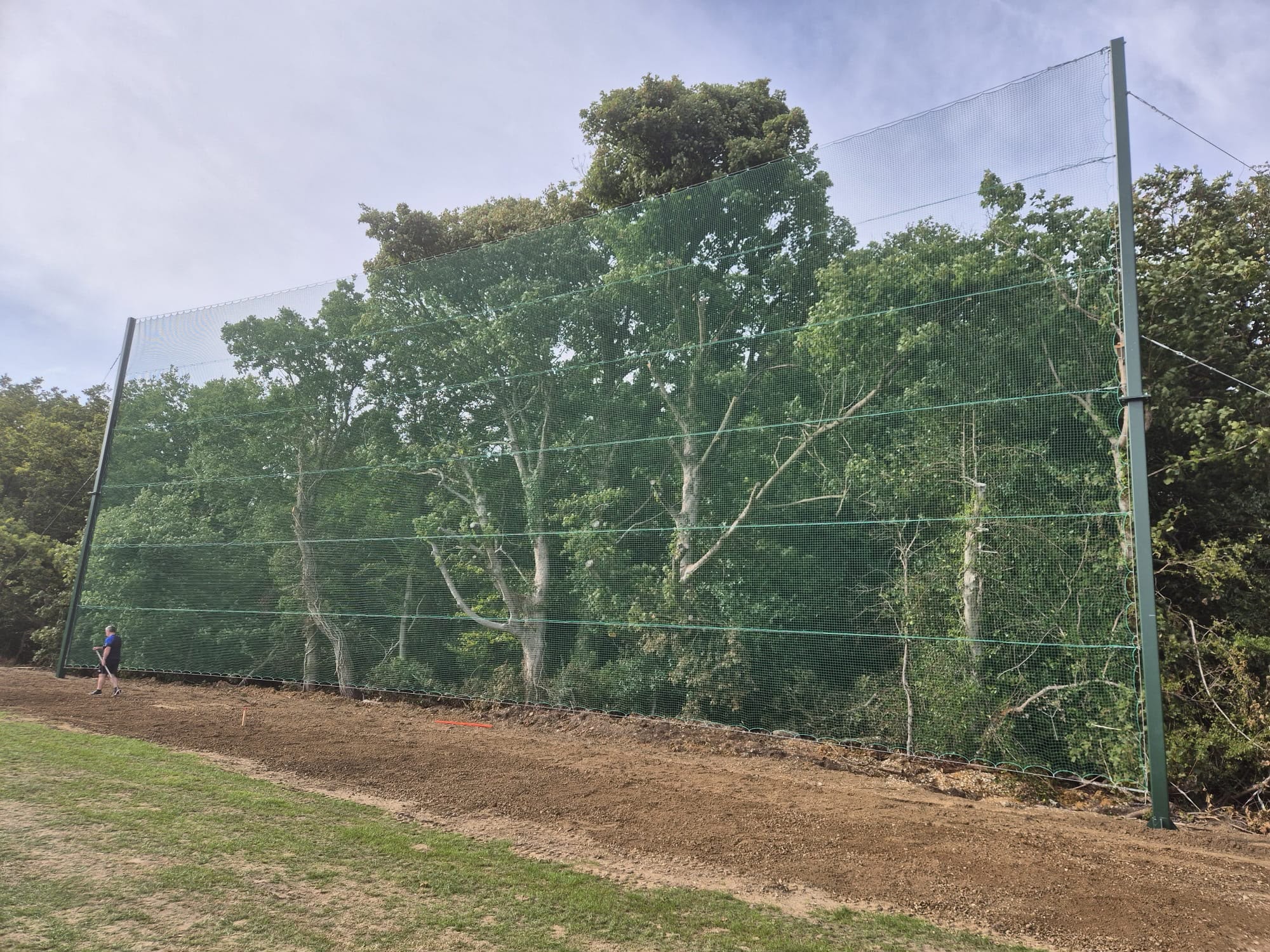 Completed green ball-catching net spanning full pitch width