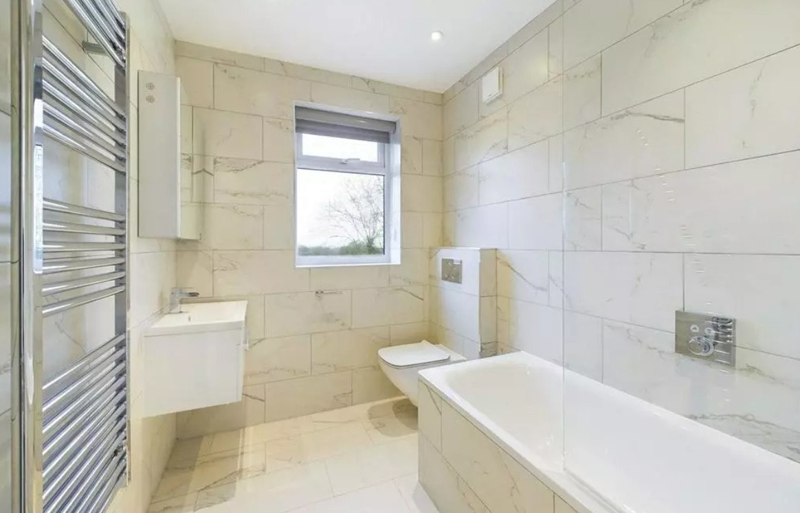 Hillside — second completed bathroom with marble tiles, heated towel rail and bath