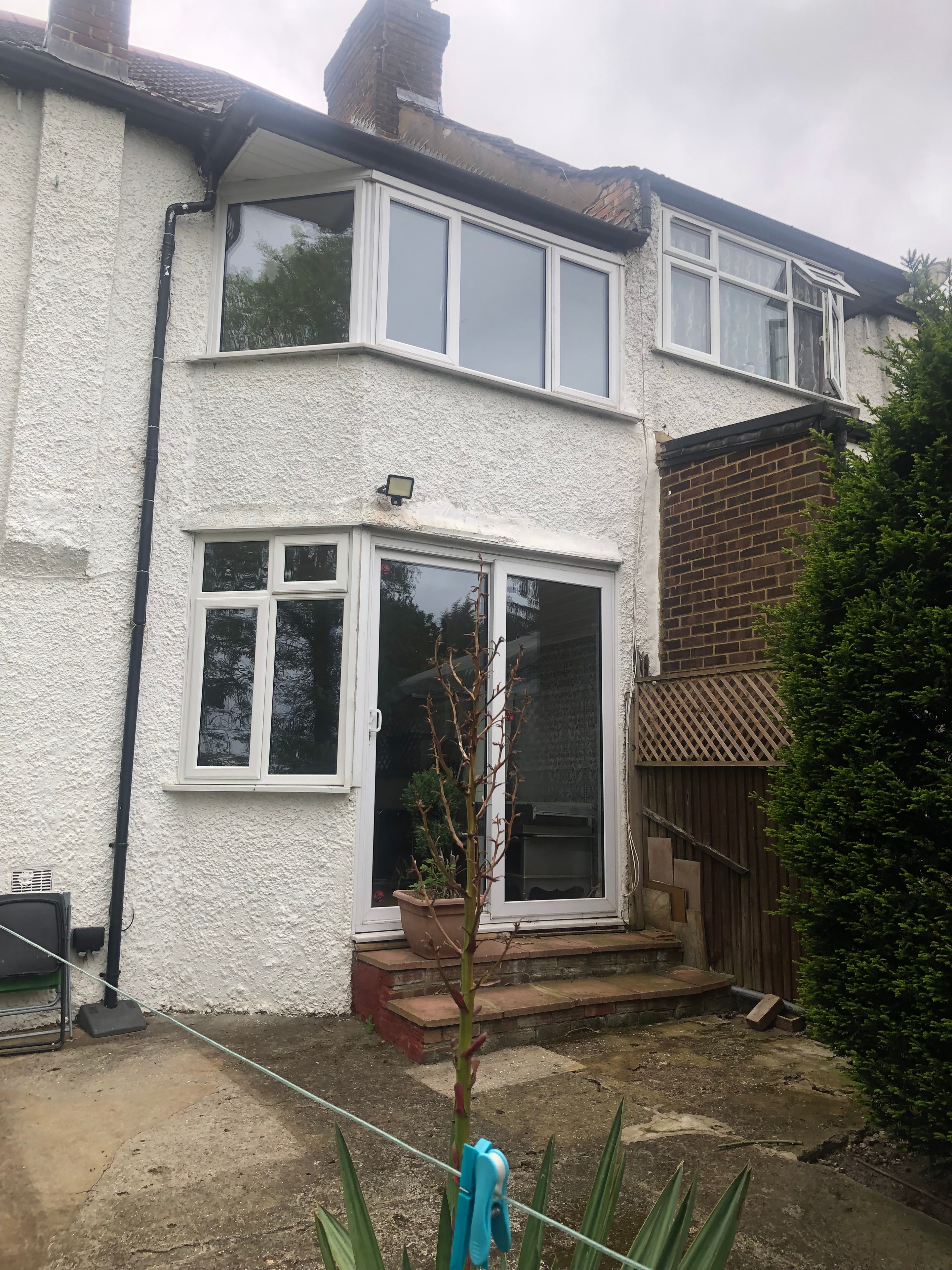 Hillside — existing rear of house before works, white render with conservatory