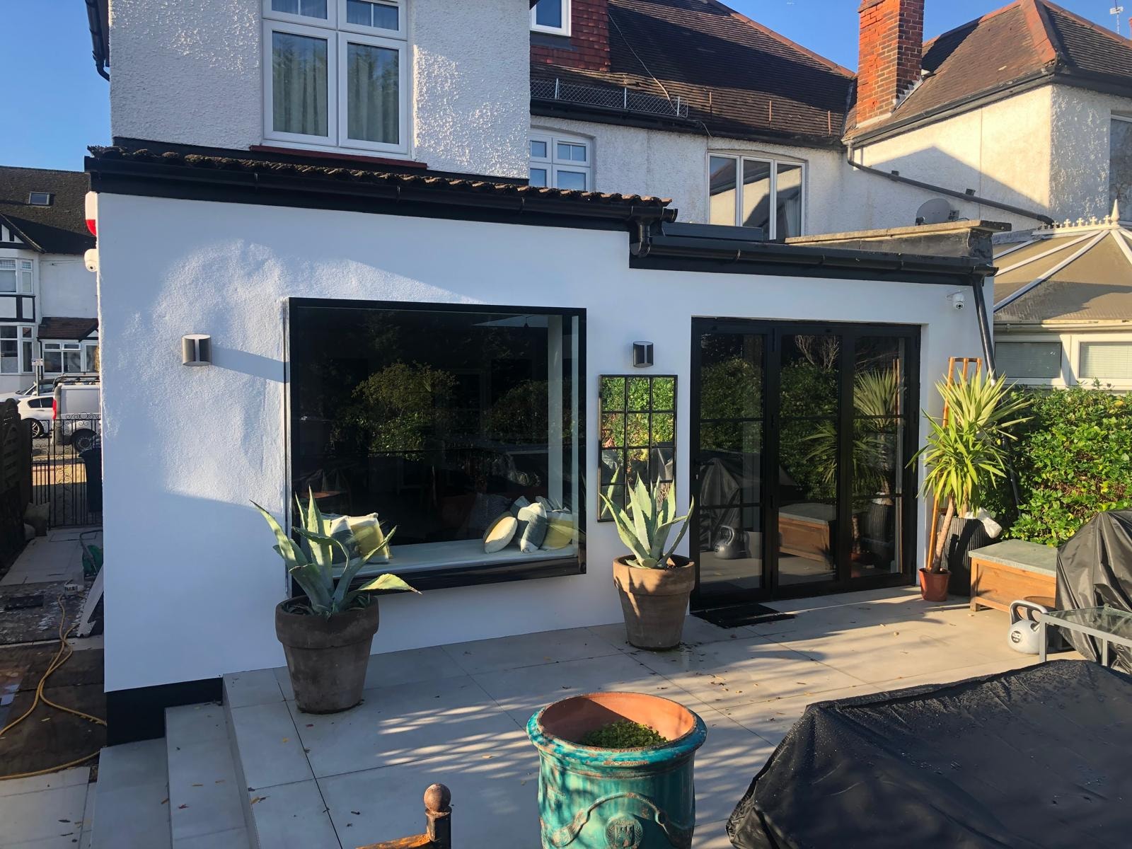 Love Lane — exterior view of completed side extension with black framed glazing and patio