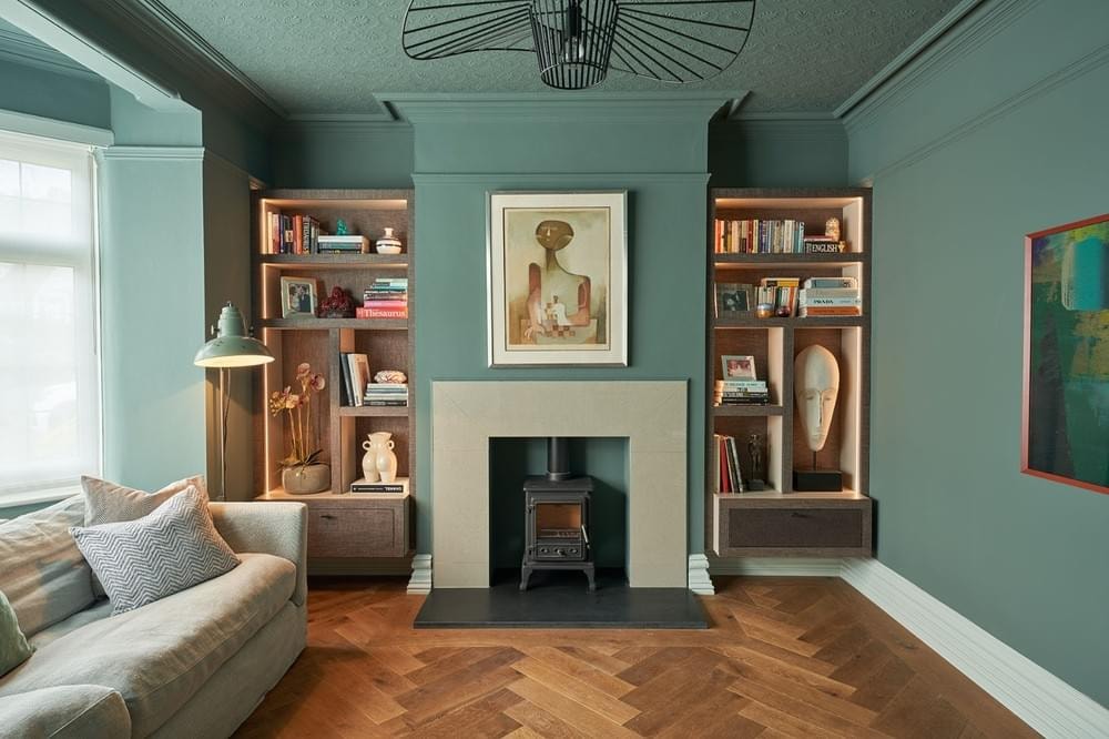 Love Lane — sitting room with teal walls, herringbone parquet floor, fireplace and bespoke alcove shelving