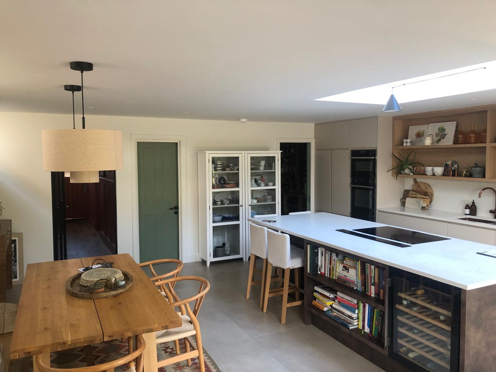 Love Lane — kitchen dining area with wooden dining table, bar stools and open plan layout