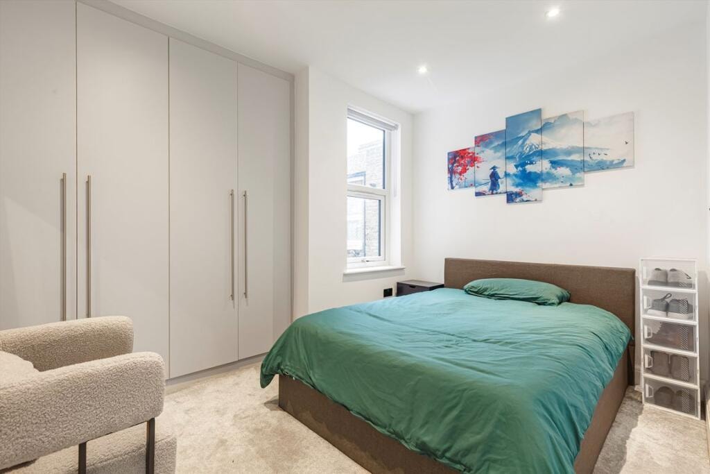 Melbourne Avenue — bedroom with green duvet, built-in grey wardrobes and Japanese-inspired wall art