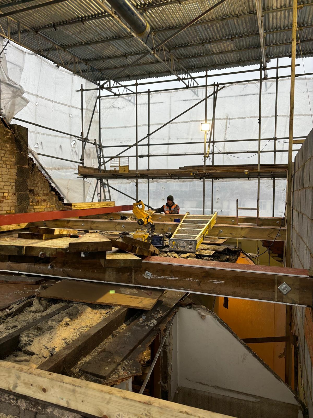 Pursley Road — loft conversion structural works with scaffolding, worker and new floor joists being installed