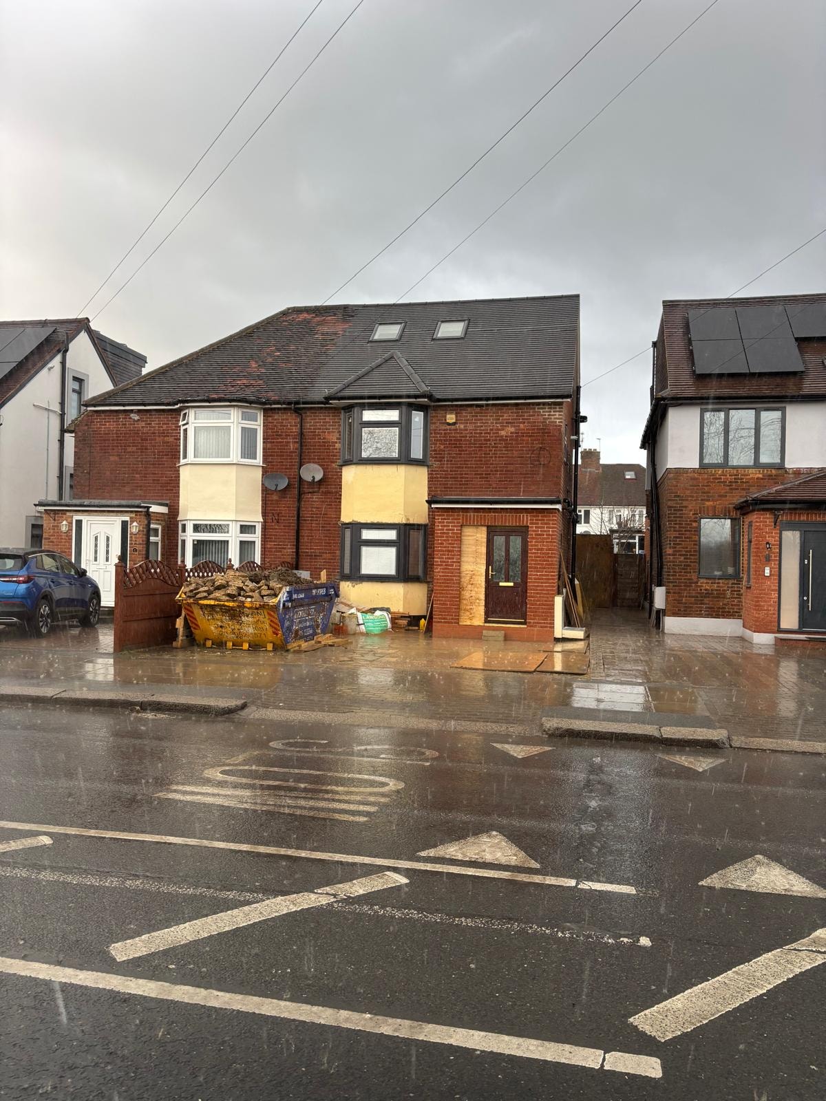 Pursley Road — exterior front elevation during construction with skip on drive and loft conversion dormer visible