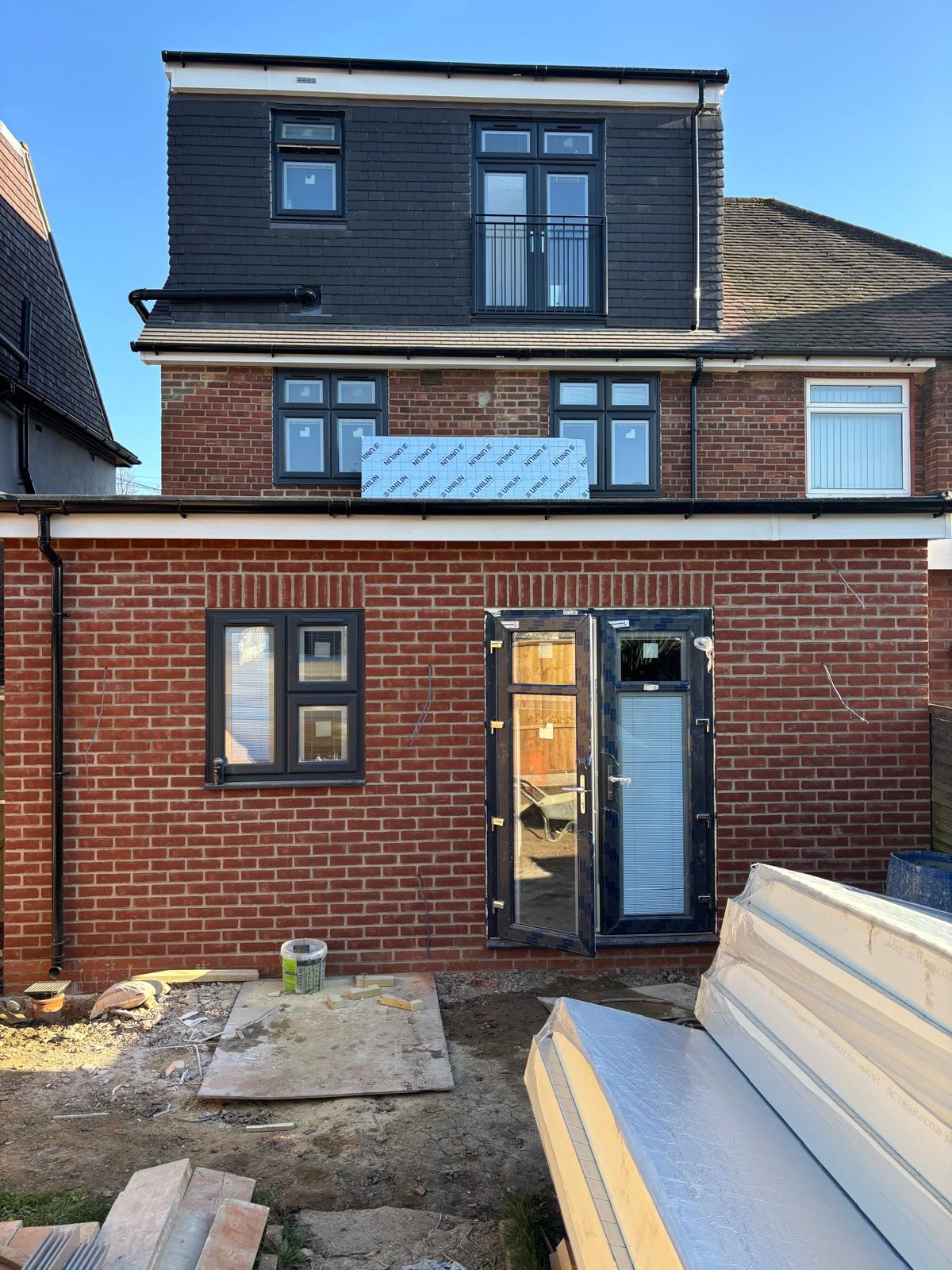Pursley Road — rear extension brick construction nearing completion with new dark-framed French doors installed