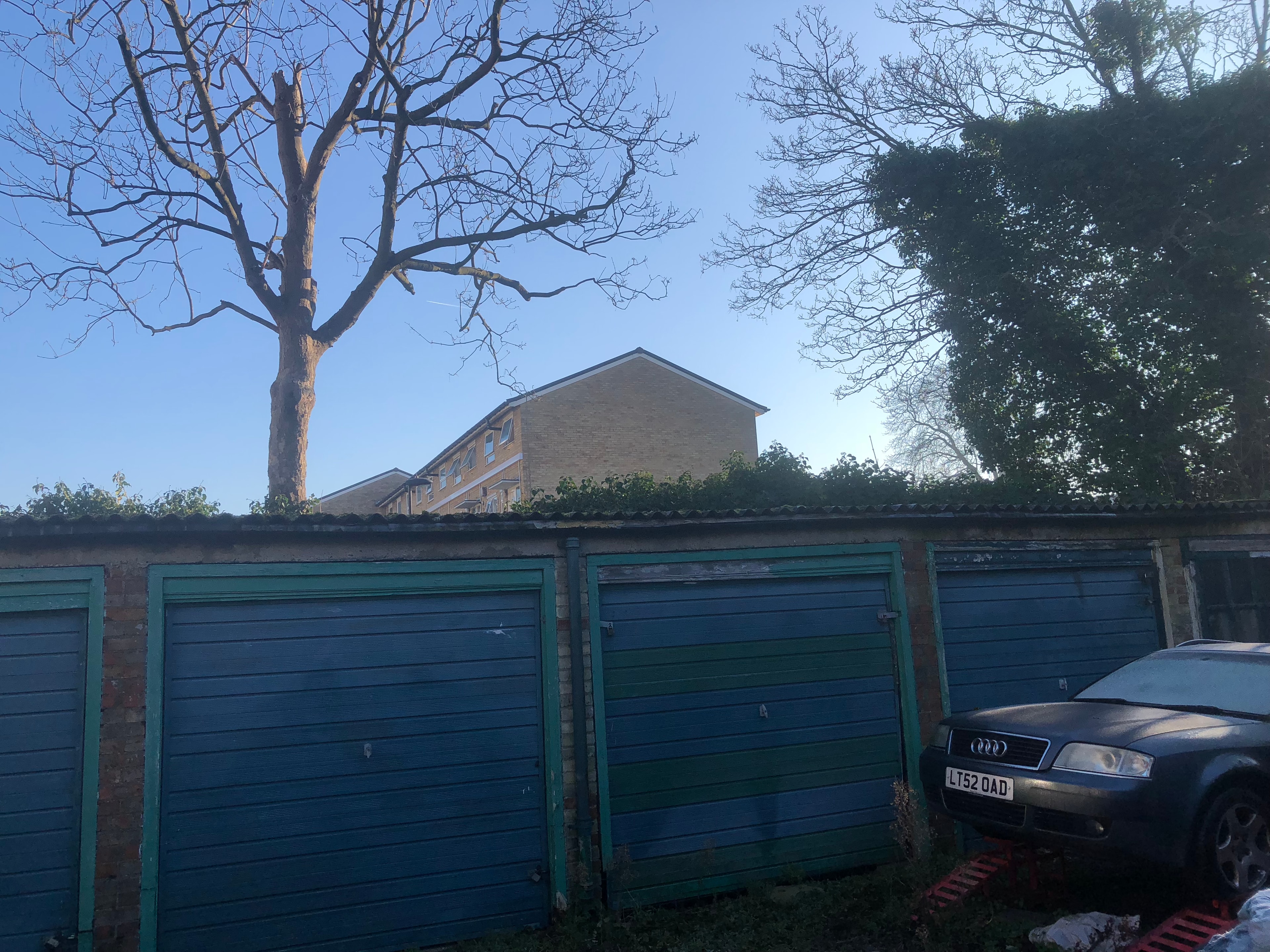 Station Road — existing garage site showing green roller doors and parked vehicles