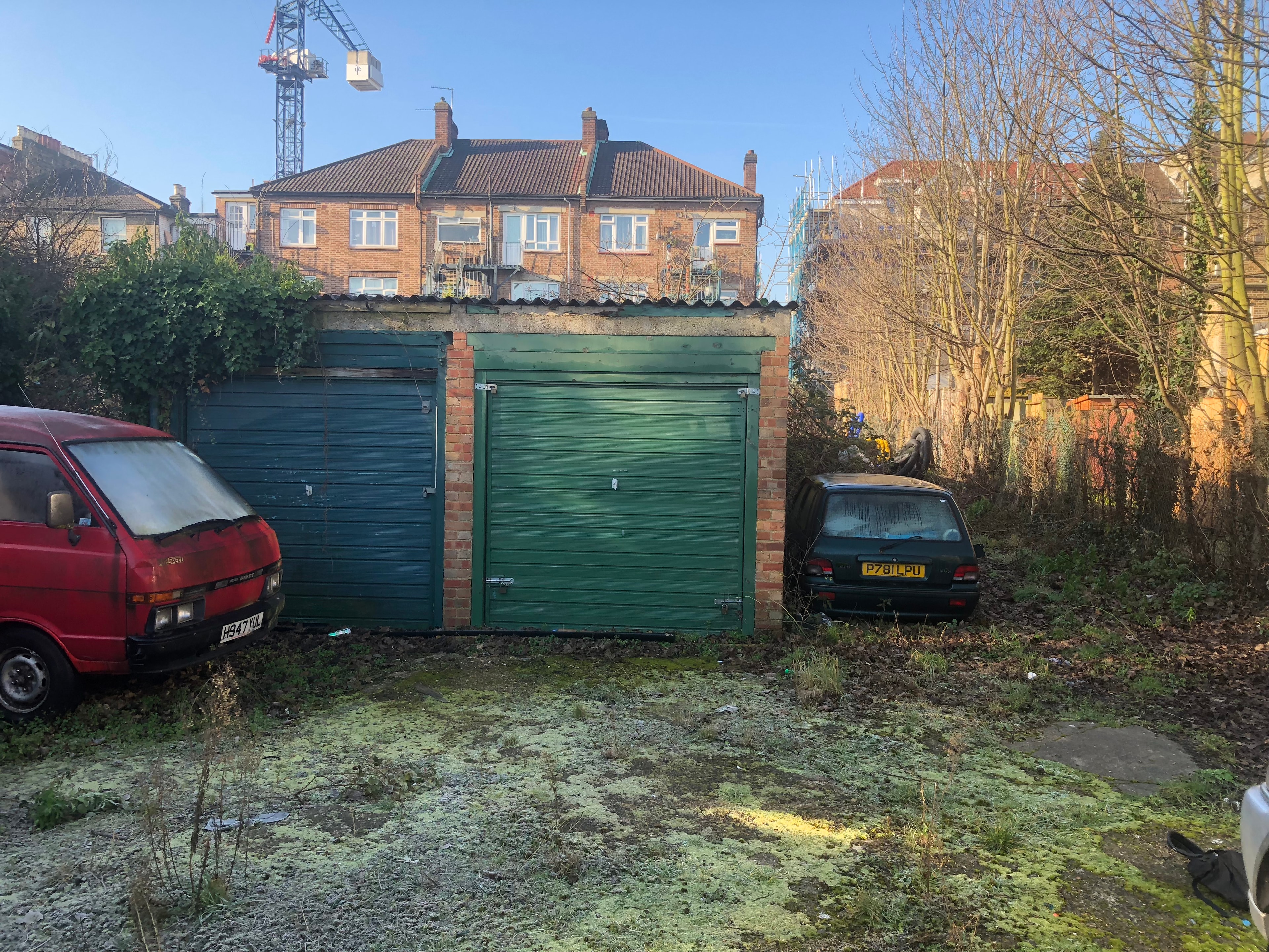 Station Road — existing green garage doors with abandoned vans and cars on site