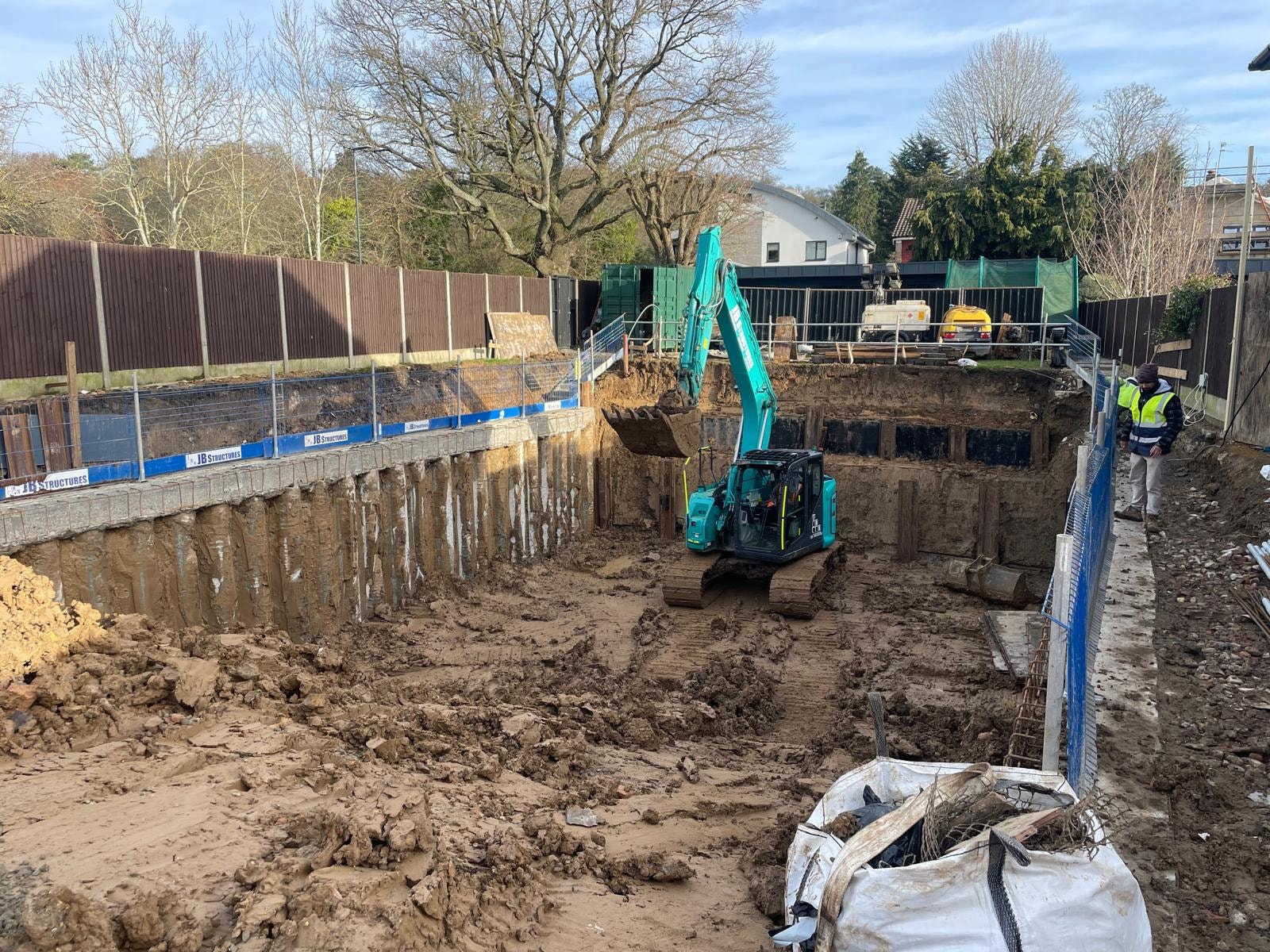 Bellfield Avenue — deep basement excavation with sheet piling retaining walls and excavator on site