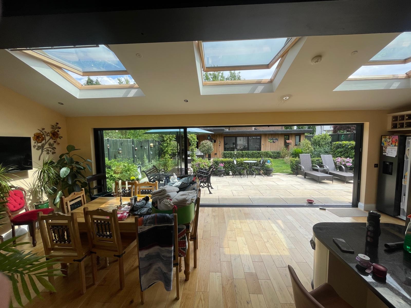 Open-plan kitchen and dining area with skylights and patio doors