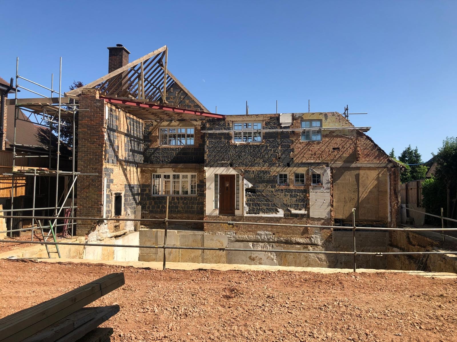 The Comyns — historic stone house under renovation with scaffolding