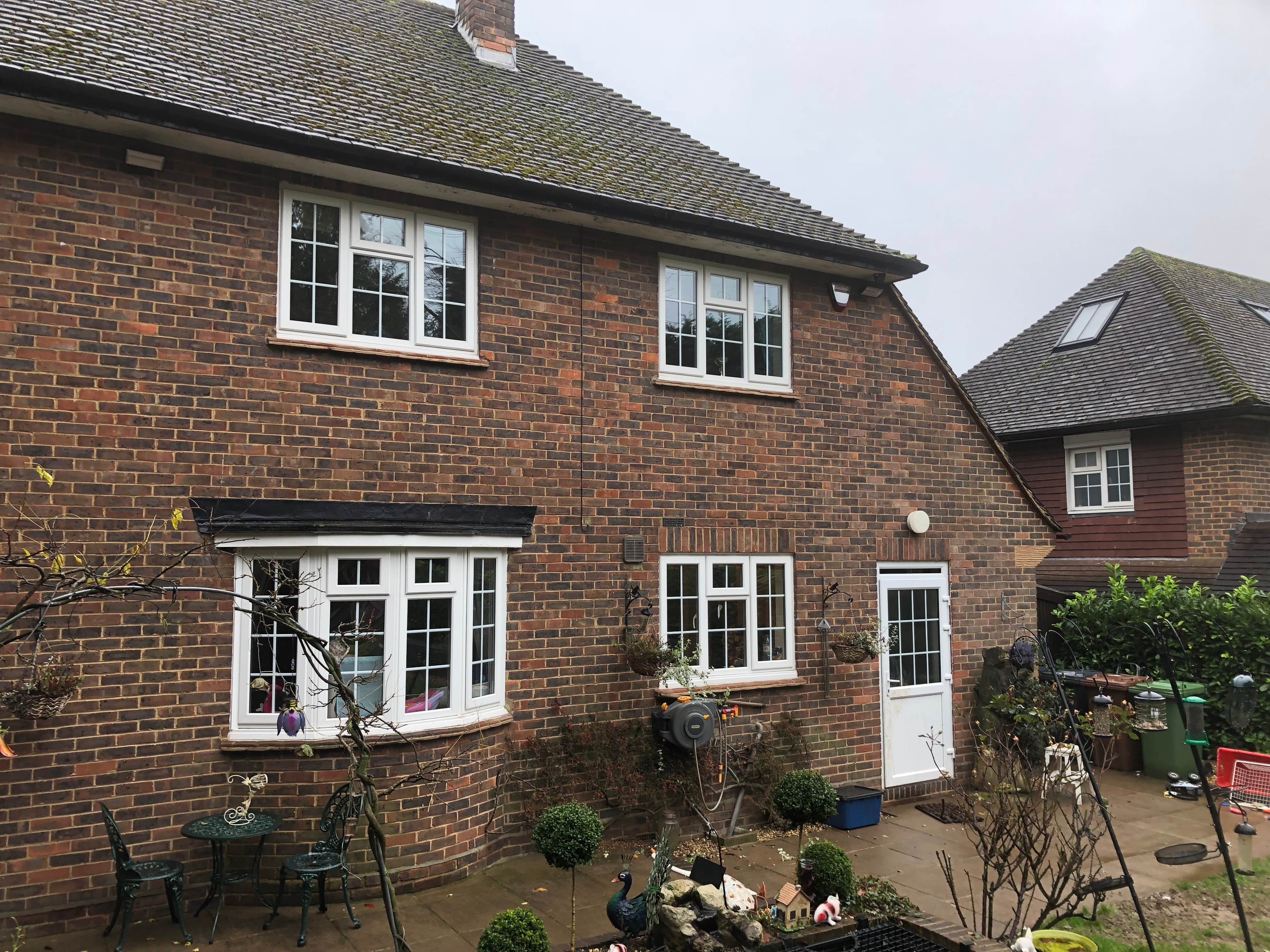 The Comyns — original rear aspect showing brick cottage with white windows and patio